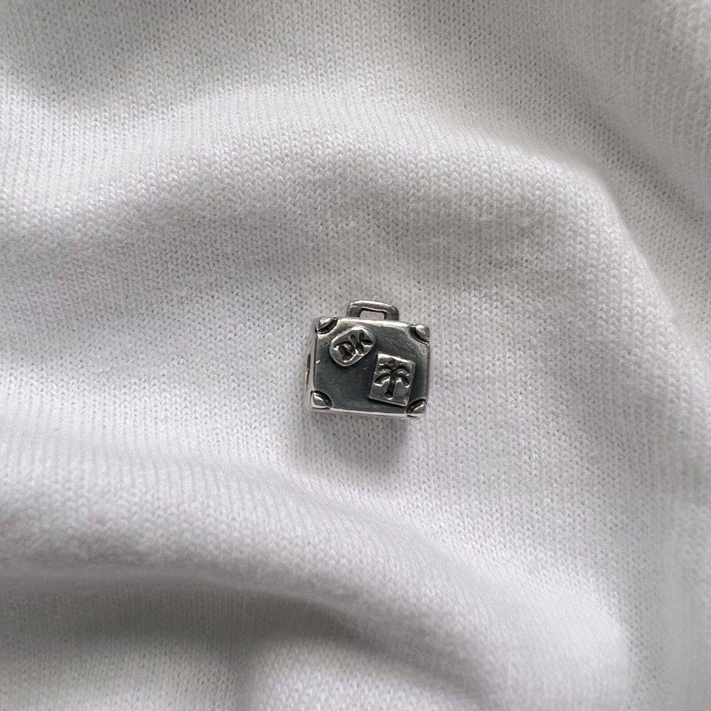 Authentic pandora 925 silver threaded core travel suit case charm.